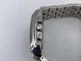 someone is holding a watch on their wrist on a white surface