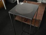 a small table with a black top in a room with bunk beds