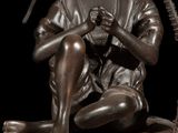 bronze statue of a boy sitting on a rock with a stick in his hand