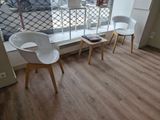 two white chairs and a table in front of a window