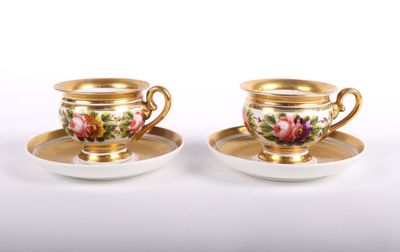 deux tasses et soucoupes ornées de bordures dorées et de motifs floraux