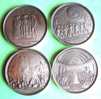 four coins with a picture of people on them on a green surface