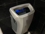 un urinoir situé dans un coin des toilettes, éclairé par une lumière bleue