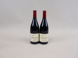 deux bouteilles de vin rouge posées l'une à côté de l'autre sur une surface blanche