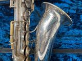 a silver saxophone sitting on a blue velvet case