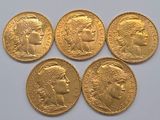 four gold sovereigns of different sizes and shapes