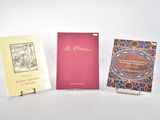 trois livres posés sur une table, les uns à côté des autres, sur une surface blanche