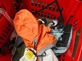 a red shopping basket filled with clothes and other items