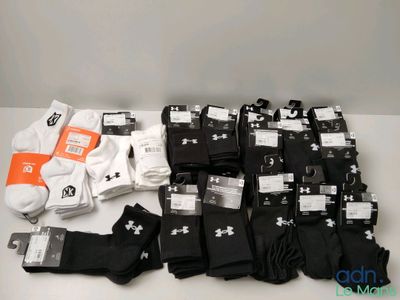 Plusieurs paires de chaussettes noires et blanches sont posées sur une table