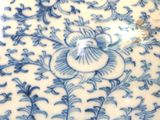 a blue and white vase with a floral design on it
