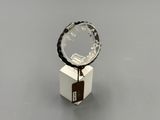 a small glass object with a tag on it