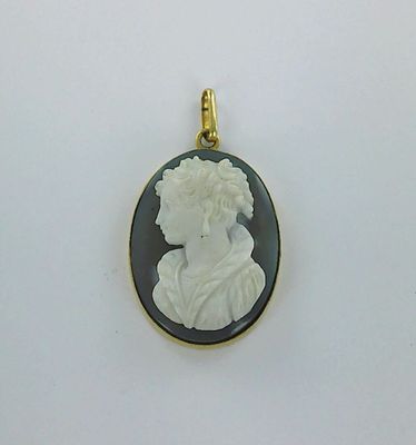 une image représentant un pendentif camée en noir et blanc représentant le visage d'une femme