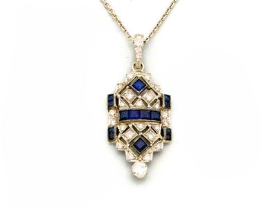 un pendentif Art déco orné de pierres bleues et blanches, monté sur une chaîne en or