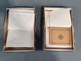 pair of open boxes with papers in them sitting on top of a table