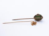 a close up of a gold and green broochle broochle on a white background