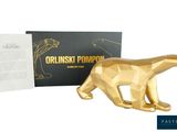 figurine d'un ours doré devant une boîte noire recouverte d'une feuille d'or