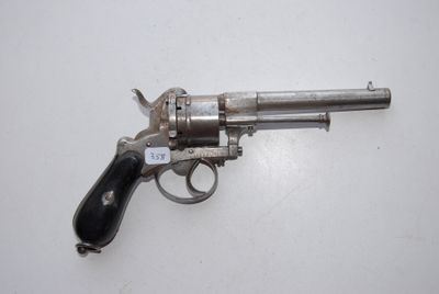 an old silver revolver with a black handle on a white surface
