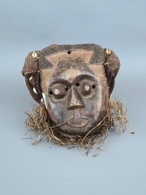 une image représentant un masque en bois sur lequel se trouve un nid d'oiseau