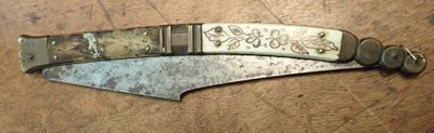 a knife that is laying on a wooden table