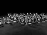 photographie en noir et blanc représentant un lot de verres à vin posés sur une table