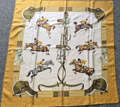 écharpe jaune avec des chevaux et des jockeys dessinés sur un tapis