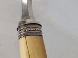 a silver spoon with a wooden handle on a pole