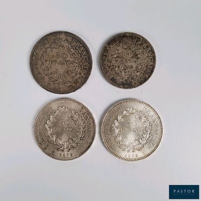 quatre types différents de pièces d'argent posées sur une surface blanche