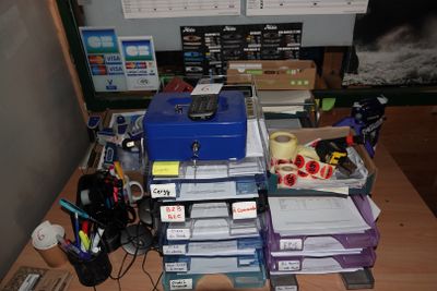 un bureau encombré, sur lequel se trouvent de nombreuses fournitures de bureau
