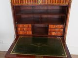 an antique writing desk with marble top and drawers