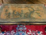 une table basse avec un plateau en verre posée sur un tapis rouge
