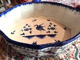 un bol bleu et blanc posé sur une table recouverte d'une nappe rouge et blanche