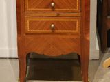 a small wooden chest of drawers with a clock on top of it