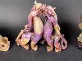 three figurines of different shapes and sizes on a black surface