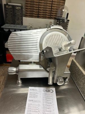 une photo d'une trancheuse à viande professionnelle posée sur un plan de travail