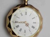 une montre de poche en or avec des chiffres romains sur le cadran