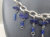 necklace with blue glass beads and silver chains on a mannequin