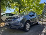 La voiture grise est garée sur le parking, près des arbres.