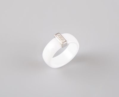 un gros plan d'une bague blanche sertie d'un diamant