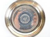 une assiette en argent sur laquelle figure le portrait d'une personne