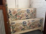 a bed with a floral design on it in the corner of a room