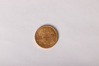 gros plan d'une pièce d'or sur une surface blanche