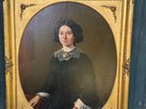 un portrait ancien représentant une femme en robe noire, dans un cadre doré