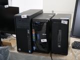 three computers sitting on a table in front of a computer monitor