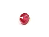 gros plan d'une pierre de rubis rouge sur une surface blanche