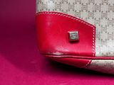 an image of a red and white purse on a pink surface