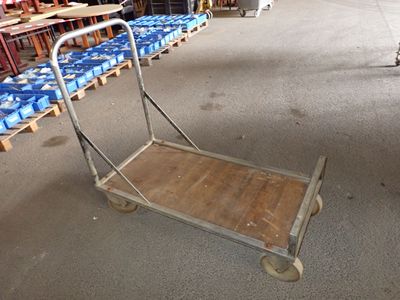 a small cart with a wooden handle in a warehouse