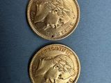 two gold coins with the image of a woman and a man on them