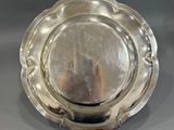 an antique silver plate with a circular design on the rim