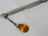 a small metal object with a yellow stone on it