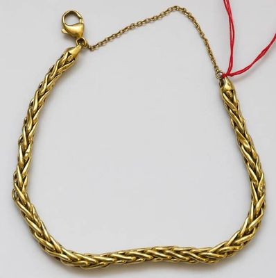 un gros plan sur un bracelet en or orné d'un cordon rouge